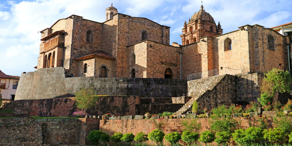 A cidade de Cusco é um destino imperdível para quem deseja compreender a grandiosidade do Império Inca. Em suas ruas de pedra, monumentos históricos e rica cultura, encontramos um lugar que representa o encontro de duas eras: o sítio arqueológico de Coricancha. Conhecido como Templo do Sol, o Coricancha é um dos edifícios incas mais icônicos, cujo esplendor foi parcialmente transformado pela construção do Convento de Santo Domingo no século XVI.
Este conteúdo traz informações estruturadas sobre como visitar, o que encontrar e por que o Coricancha continua encantando viajantes do mundo todo. Veremos a importância do local como o templo mais importante do período inca, bem como a forma pela qual a igreja de Santo Domingo se sobrepôs às antigas paredes de ouro e prata. Seja através de um city tour ou de uma visita independente, entender o passado desse templo é essencial para quem quer mergulhar na história de Cusco.
