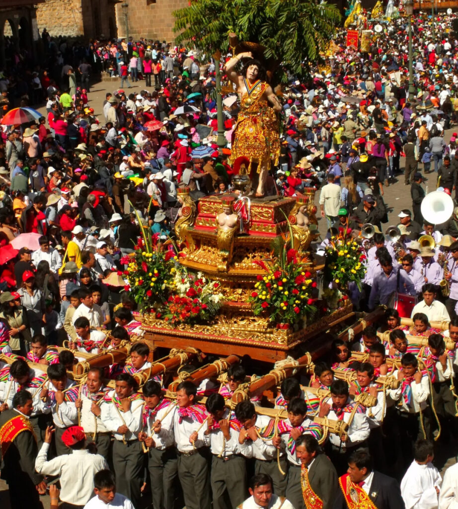 Procissão da Festa de San Sebastián em Cusco com imagem do santo carregada por fiéis, danças tradicionais e multidão reunida nas ruas durante celebração religiosa de janeiro.